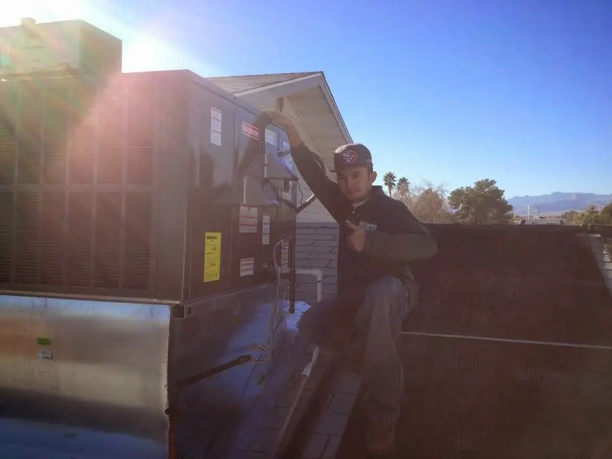 HVAC technician performing Air Duct Cleaning on a rooftop unit in Fultondale